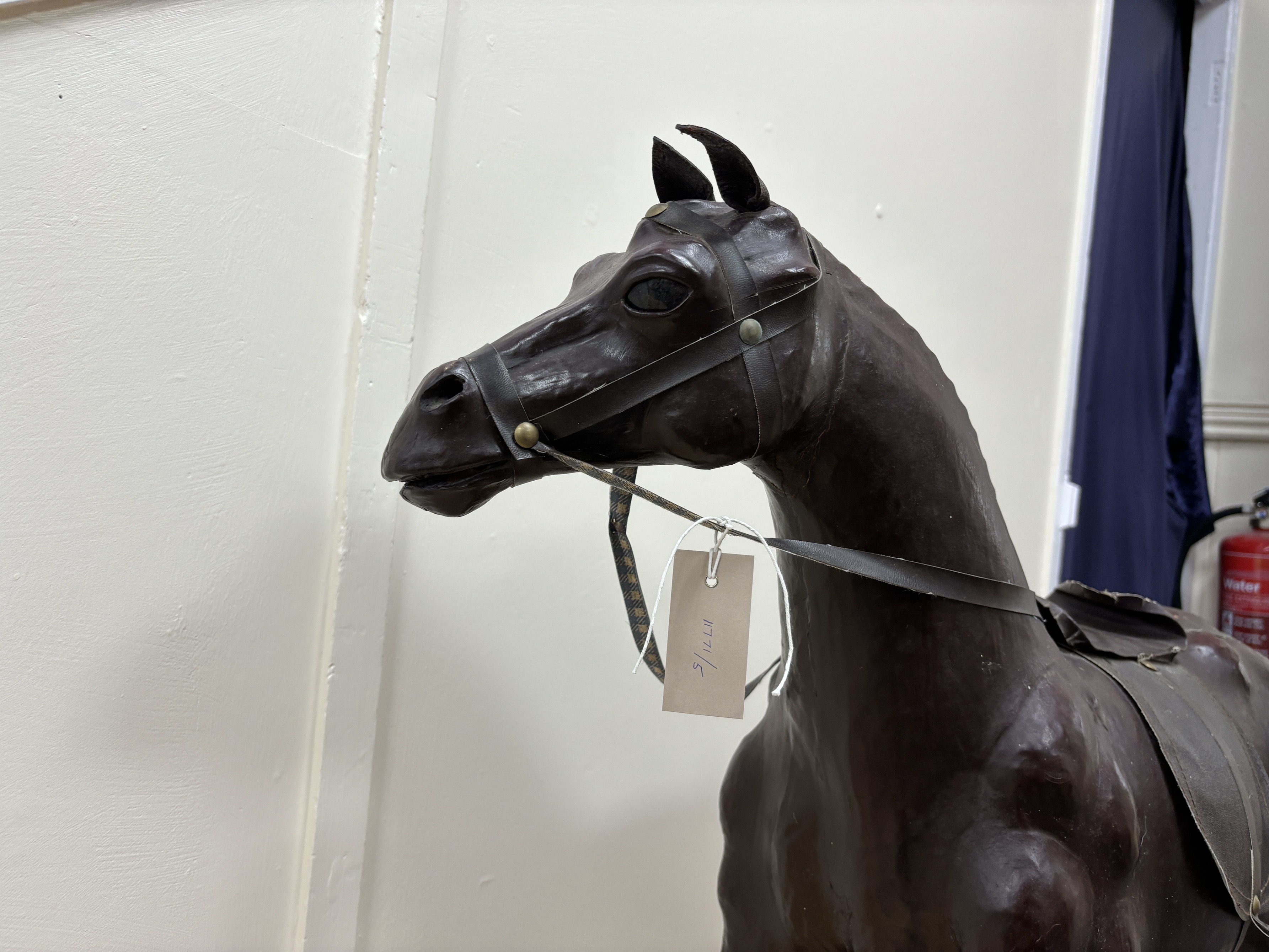 A burgundy leather covered model of a horse with faux leather tack, height 76cm